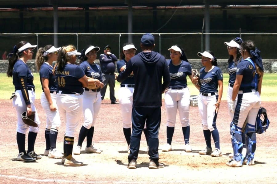 Entrenador de la UNAM con un equipo de sóftbol.