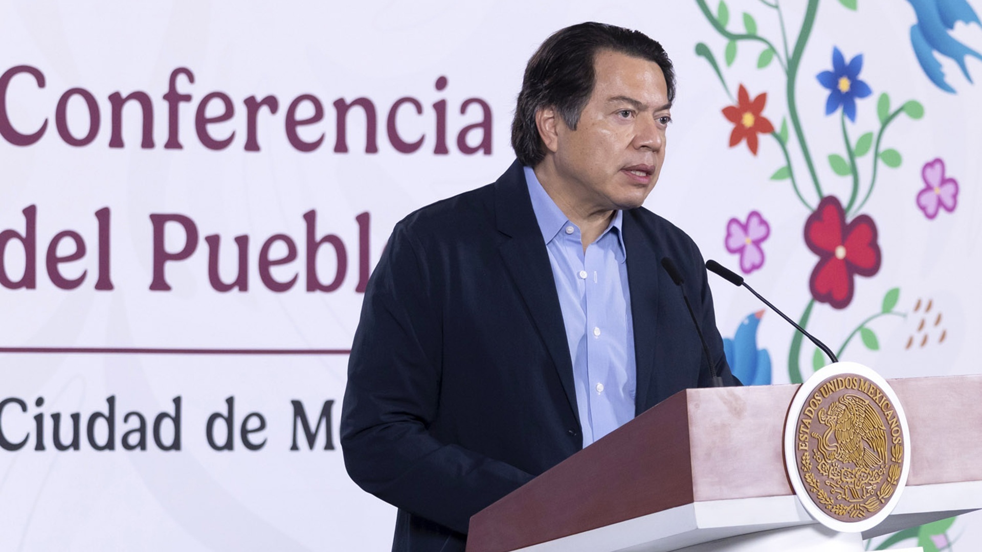 Mario Delgado con traje oscuro y camisa azul habla desde un atril con micrófono. Mario Delgado con traje oscuro y camisa azul habla desde un atril con micrófono.