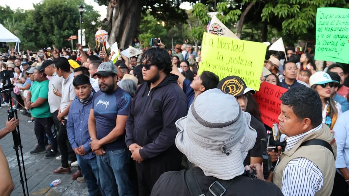 Personas en aparente actitud de bloqueo y contención se colocan frente a otro grupo de personas