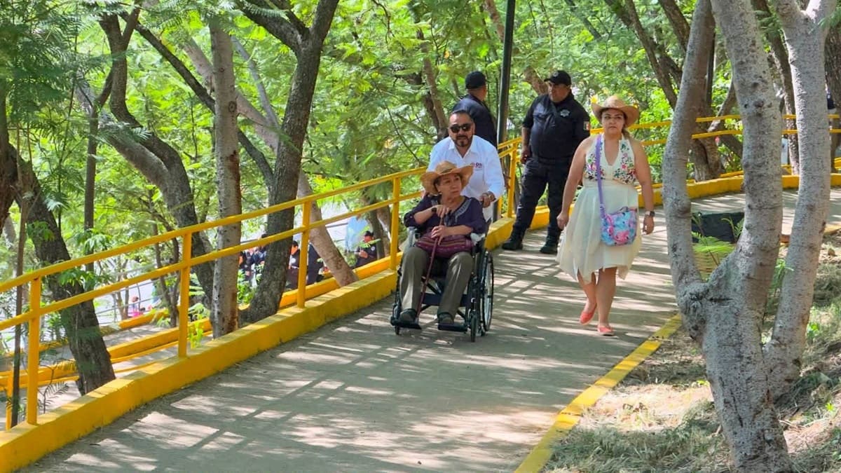 Personal del DIF de Oaxaca asiste a un adulto mayor a través de una silla de ruedas en las inmediaciones del Auditorio Guelaguetza