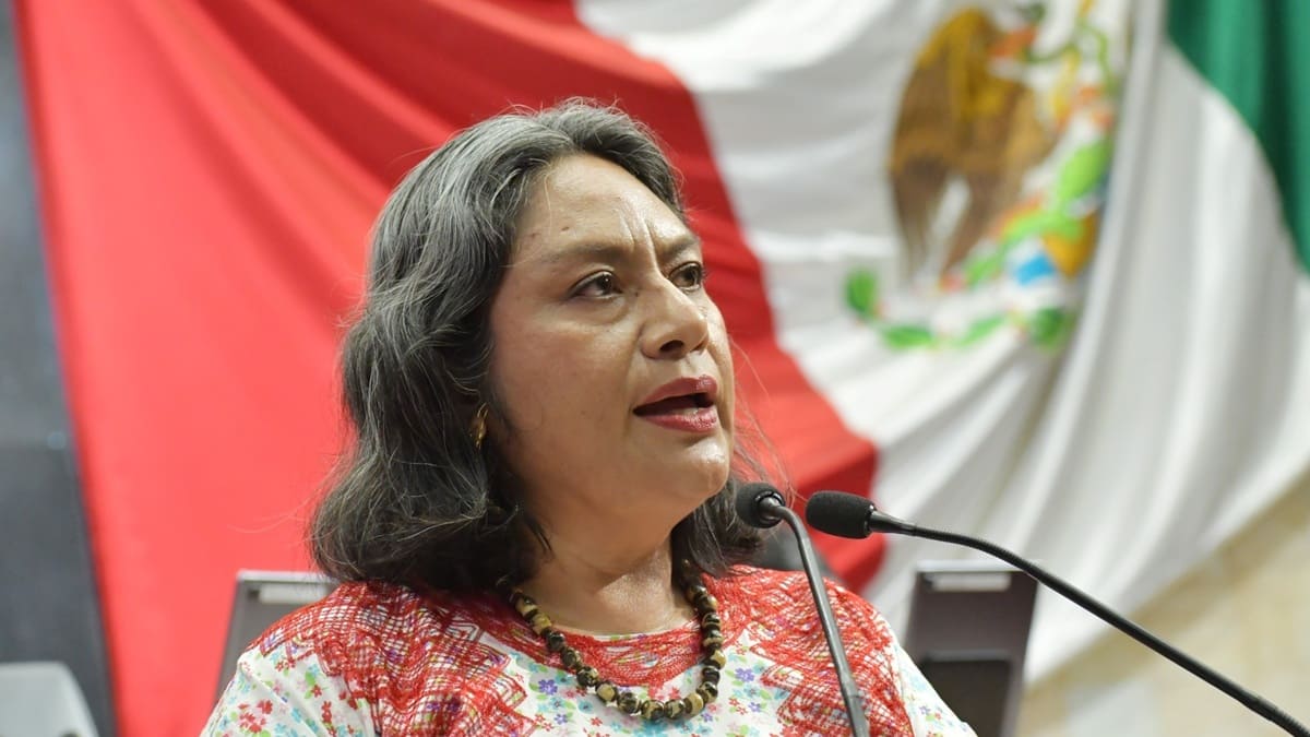 Diputada Irma Pineda con un huipil con adornos rojos ofrece un discurso frente a un micrófono en el Congreso de Oaxaca