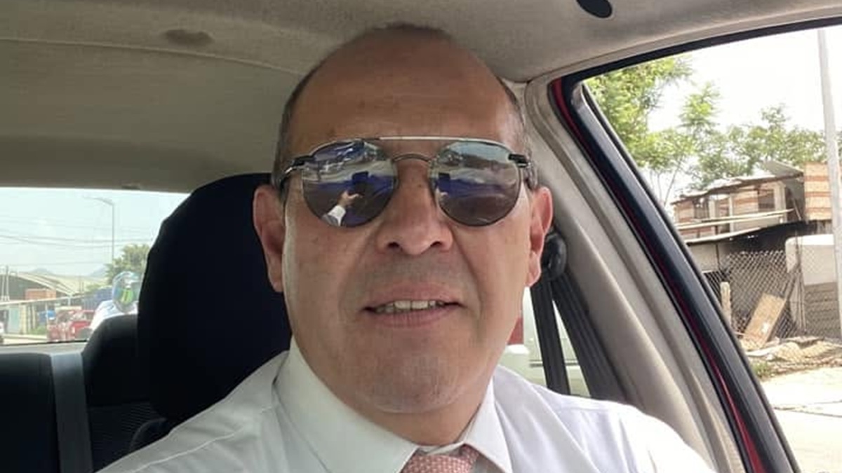 Alejandro Leyva con lentes, camisa y corbata en su auto y tomándose una selfie