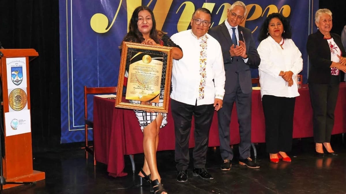 Rosa Delia Martínez vestida con elegancia muestra un reconocimiento recibido.