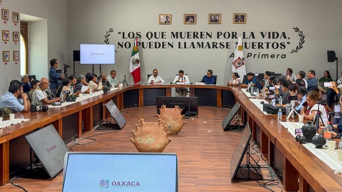 Salomón Jara en un salón sentado y reunido con decenas de periodistas