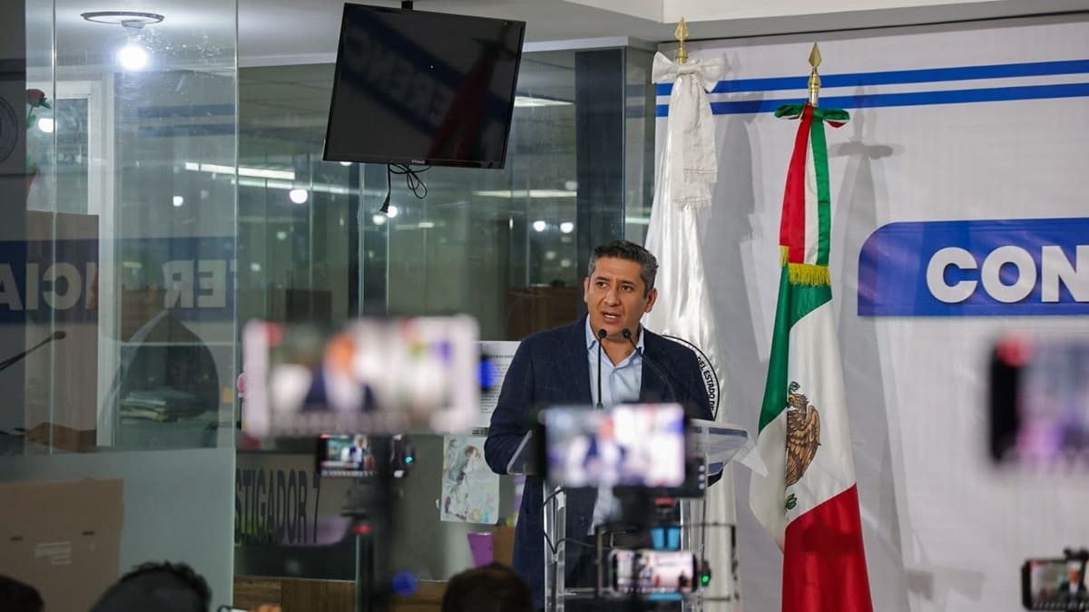 Maquinaria pesada realiza trabajos de levantamiento de asfalto en una calle de Miahuatlán, mientras gente camina por las banquetas