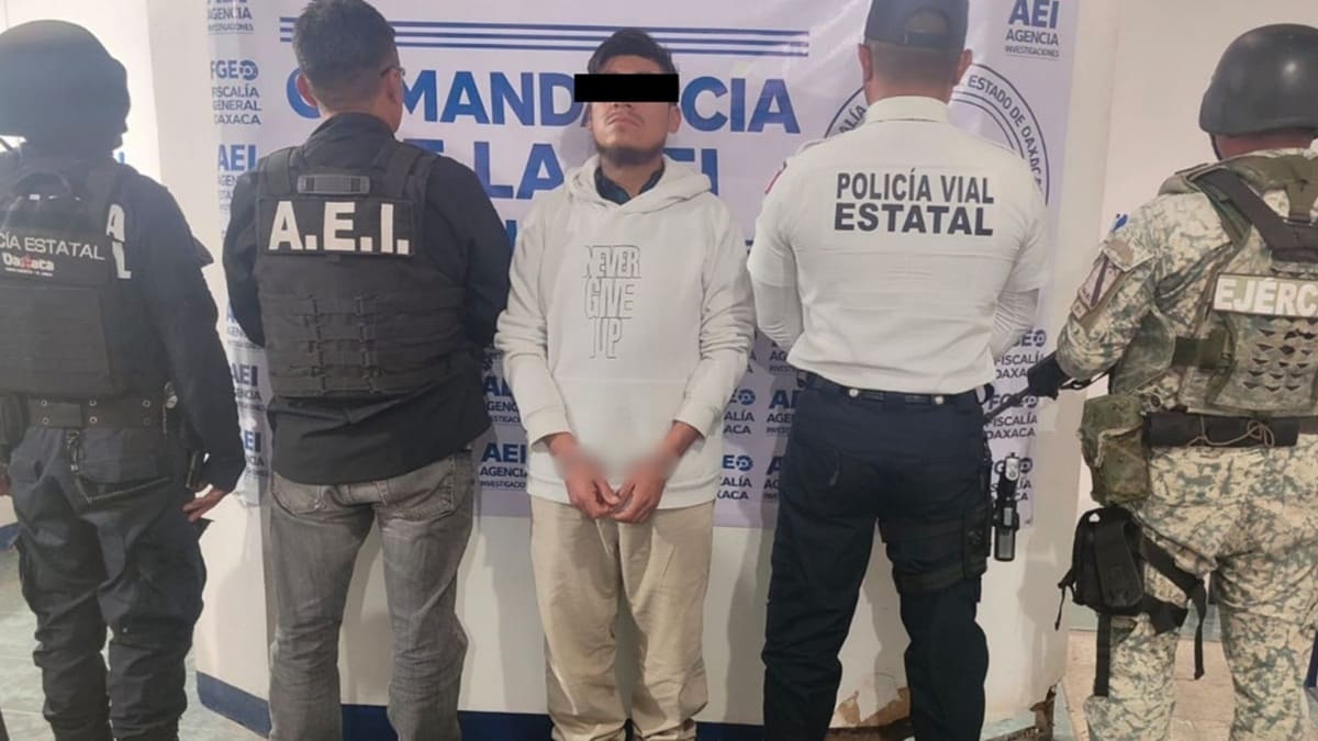 Hombre esposado con los ojos cubiertos por una franja negra por mandato de ley