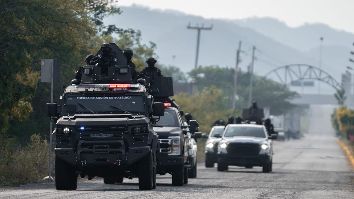 Elementos de seguridad estatal de Oaxaca a bordo de vehículos artillados avanzan sobre una carretera