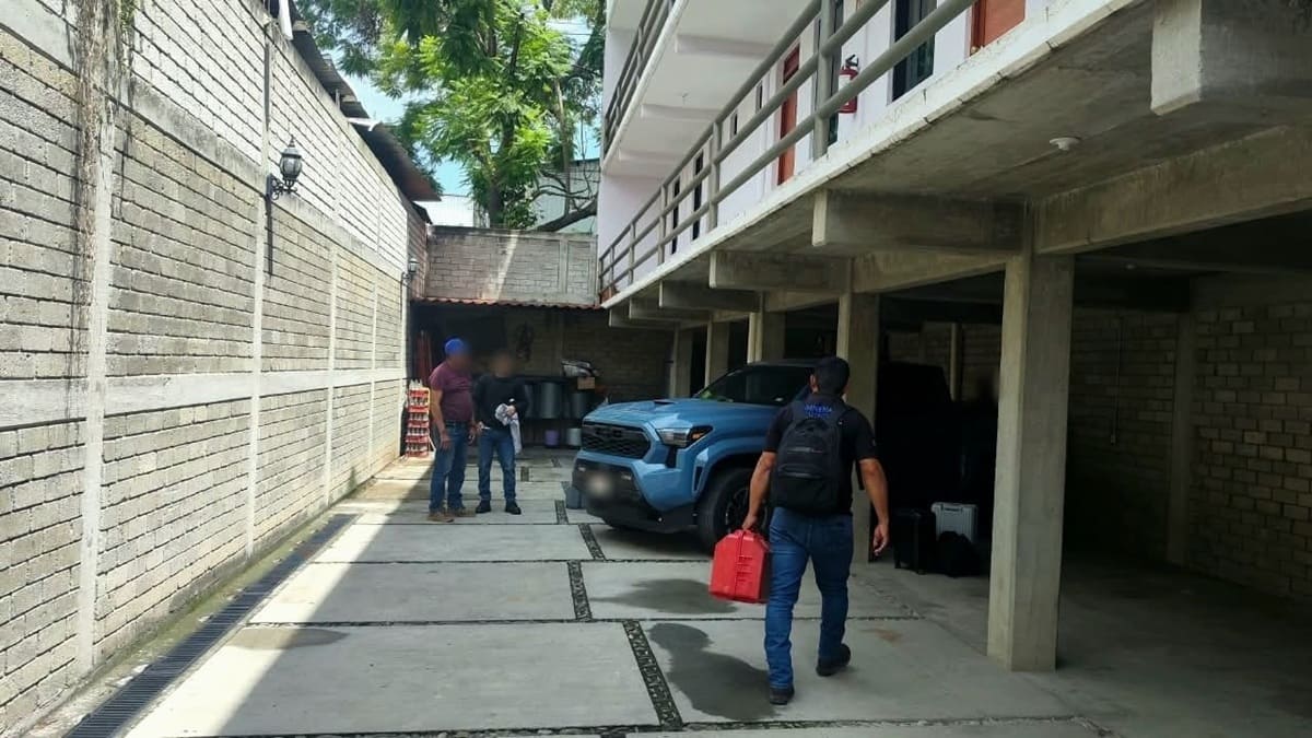 Hombres caminando en un pasillo junto a una vivienda