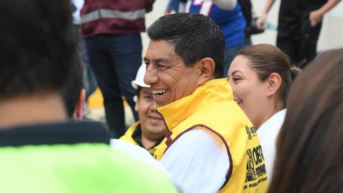 Salomón Jara junto a otras personas con un chaleco amarillo