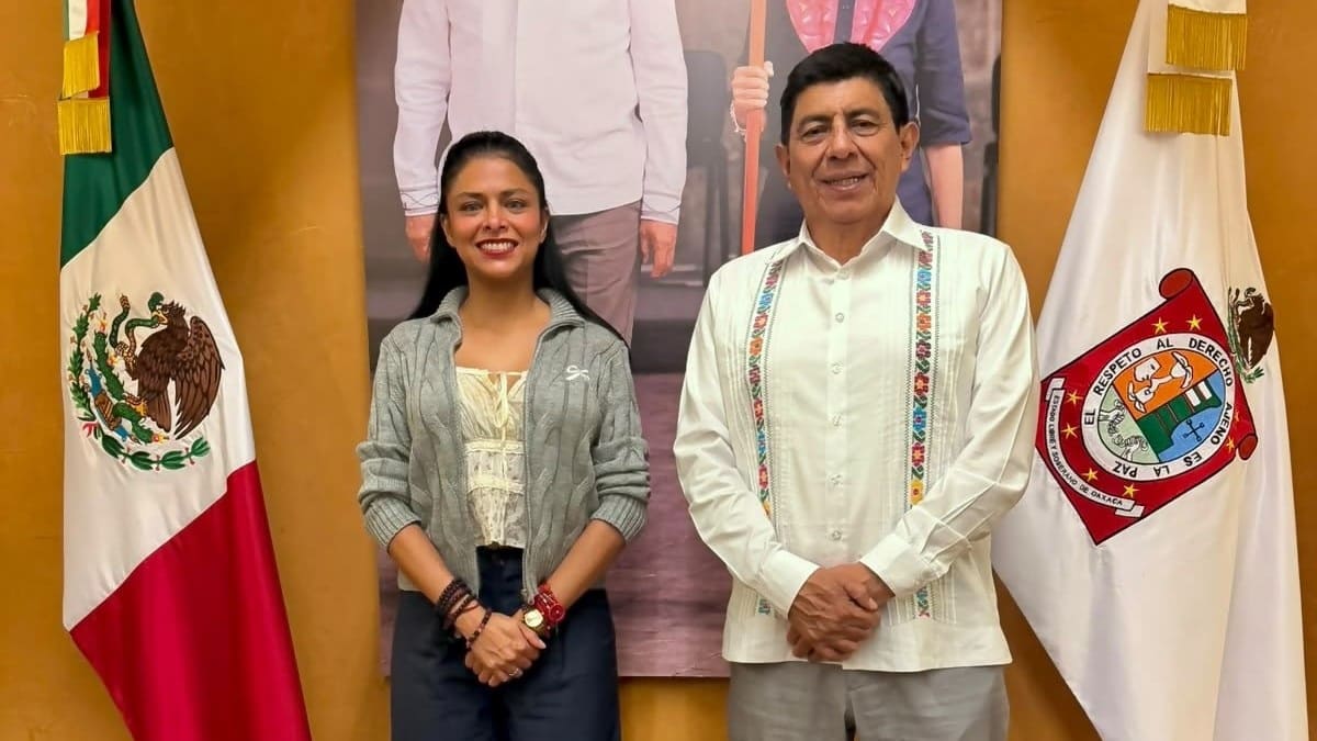 Fernanda Chávez y Salomón Jara posando para la foto junto a la bandera de México