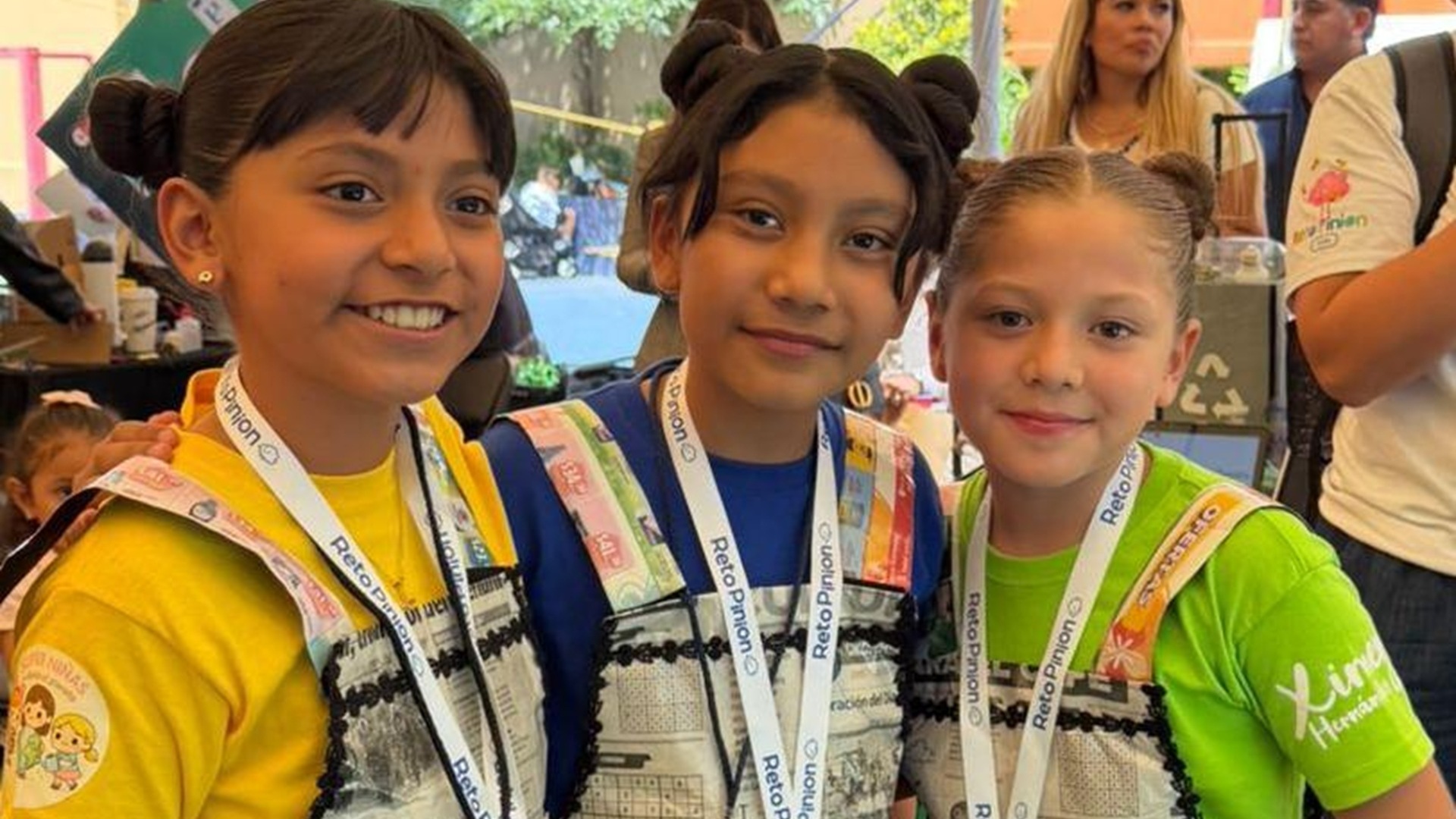 Tres niñas oaxaqueñas ganadoras del concurso Reto Pinion 2026 exhiben sus medallas.