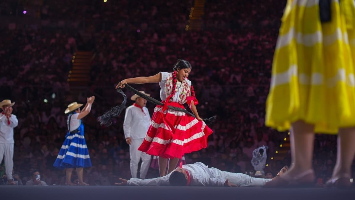 Danzantes de la Guelaguetza 2026 con trajes blancos, rojos y azules ejecutan su presentación