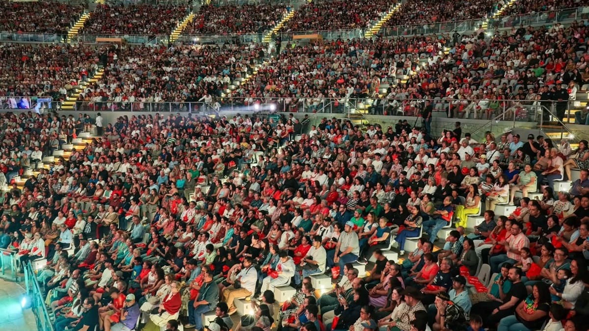 Asistentes en el Auditorio Guelaguetza permanecen sentados observando lo que se presenta en el escenario