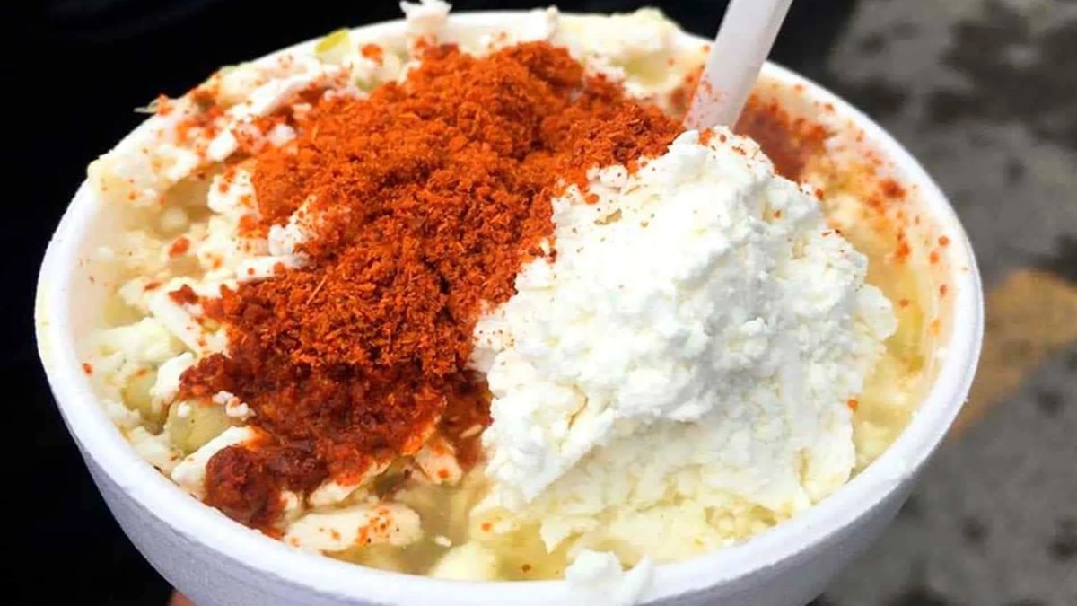 Imagen de un vaso de unicel con granos de elote, queso y chile en polvo