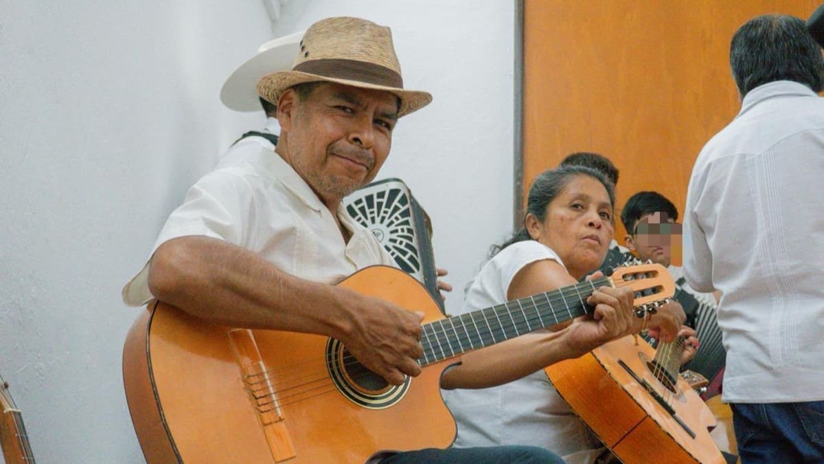 Adultos mayores sosteniendo guitarras en un patio