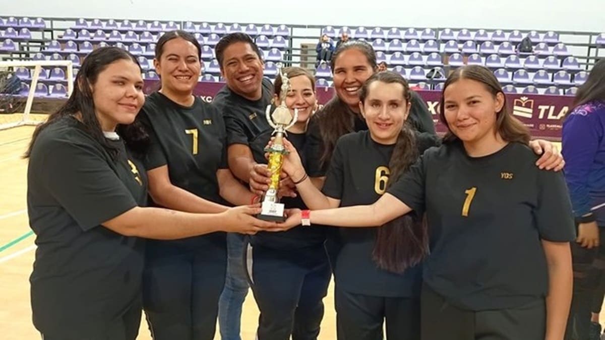 Equipo mexicano de golbol con uniforme deportivo mostrando un trofeo