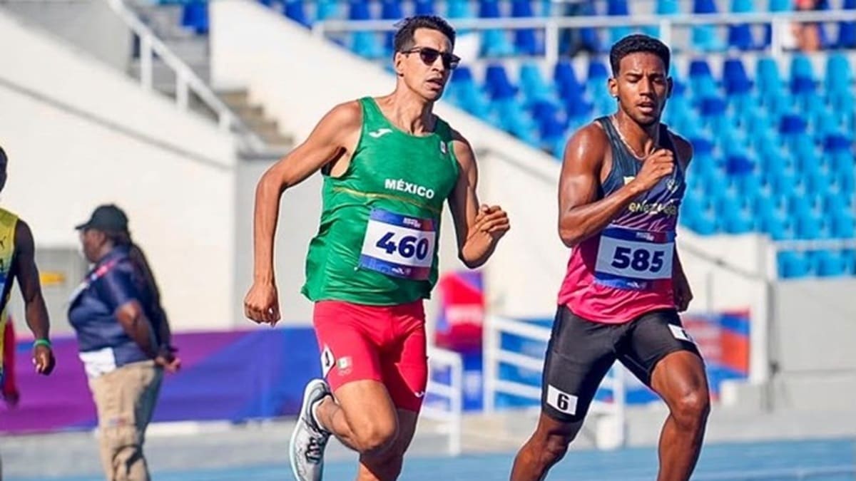 Jesús Tonatiú López con uniforme deportivo de México corre en su prueba en Santo Domingo, junto a un competidor