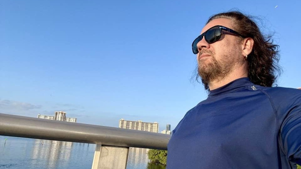 Imagen de perfil del artista Osamu Menéndez caminando por una bahía.