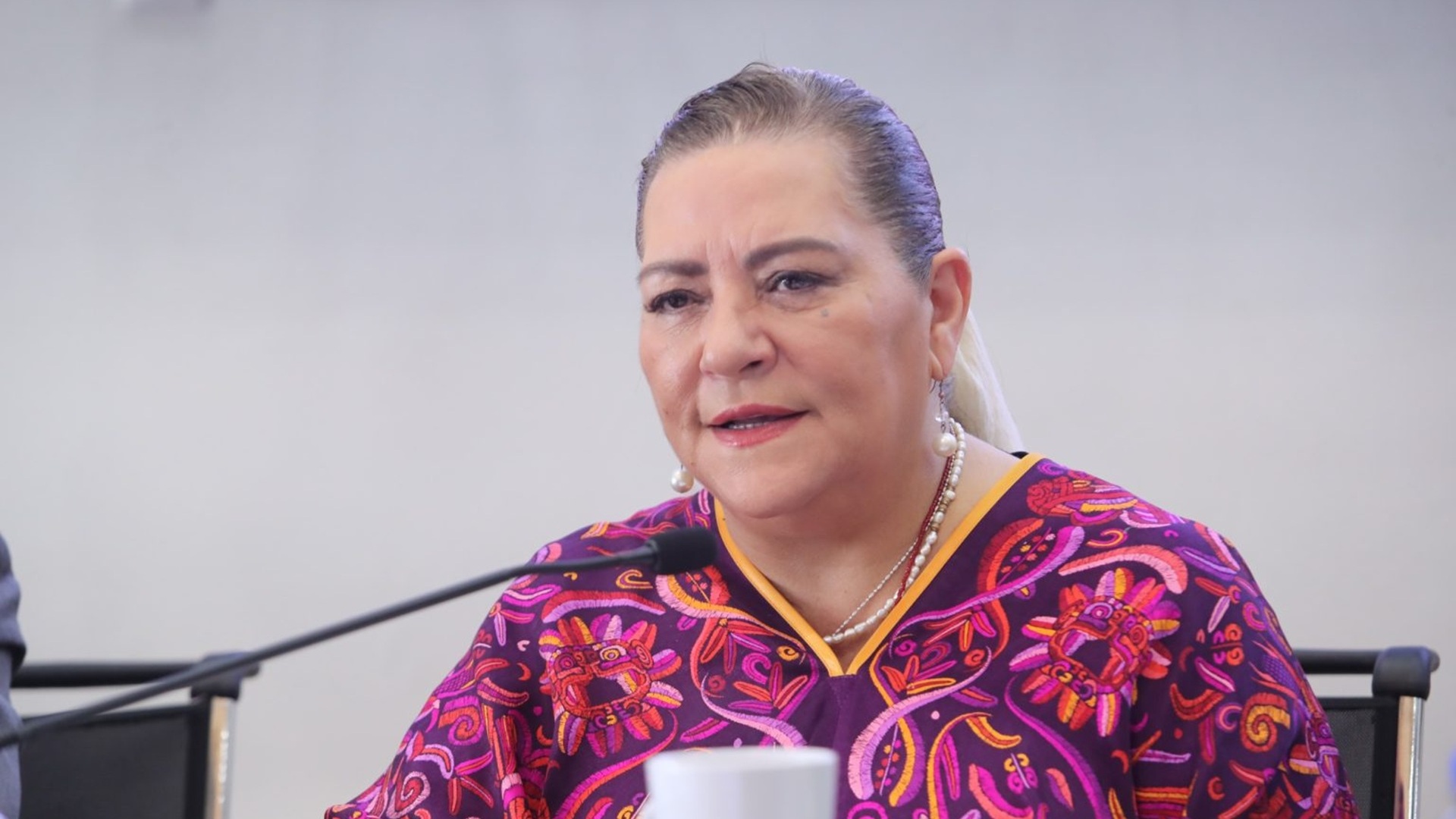 Guadalupe Taddei con traje regional habla junto a un micrófono.