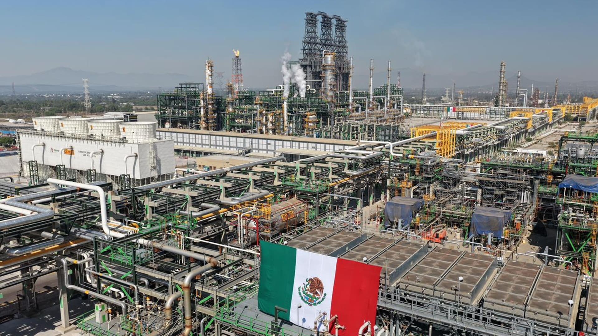 Toma aérea de instalaciones de Pemex en una gran extensión de terreno, entre tuberías y torres industriales.
