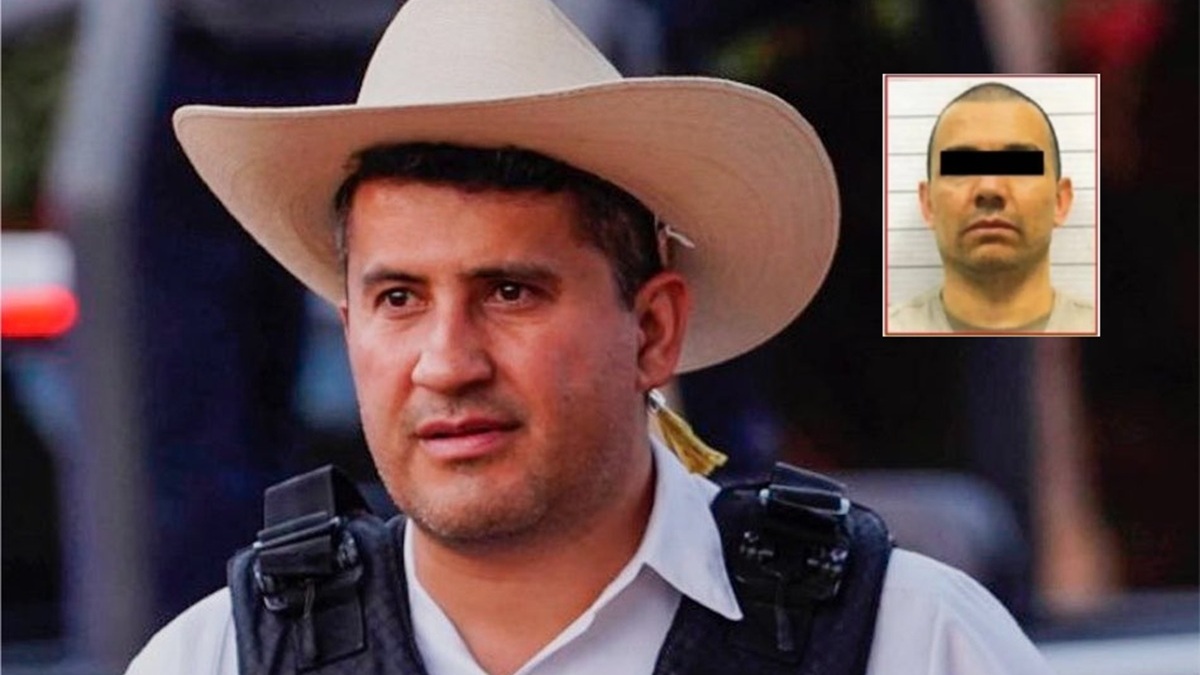 Carloz Manzo con chaleco táctico y sombrero, junto a una ventana donde se exhibe al R1