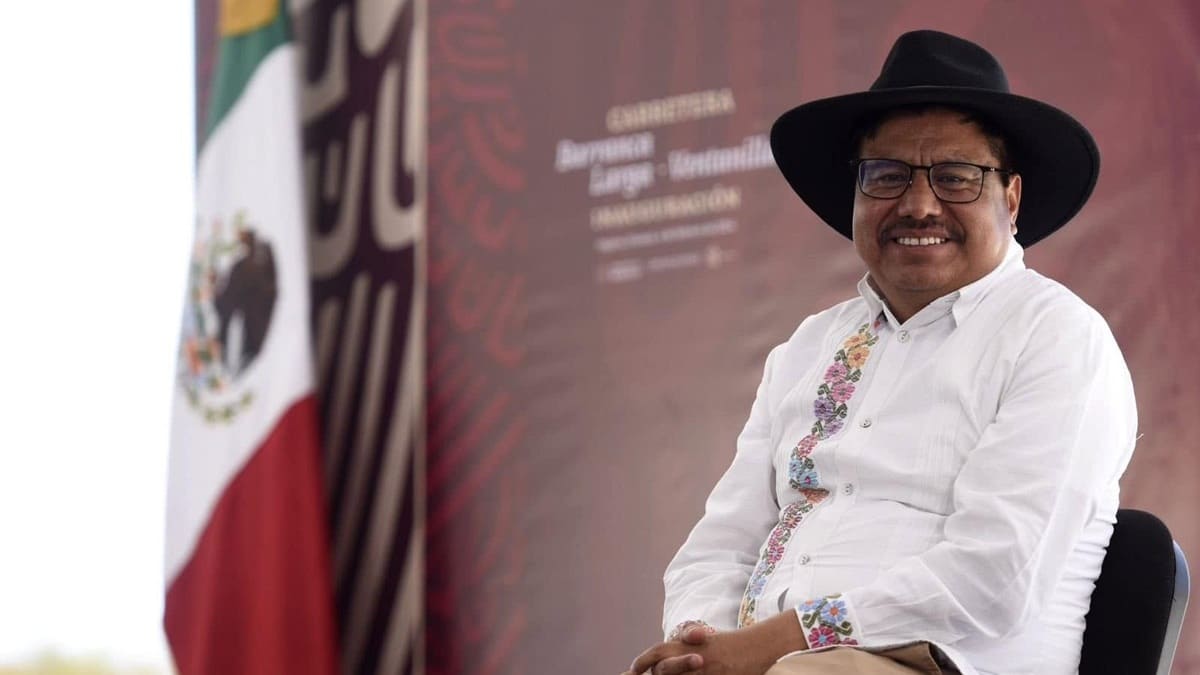 Adelfo Regino, con camisa de bordados típicos de Oaxaca y sombrero, sentado y sonriente