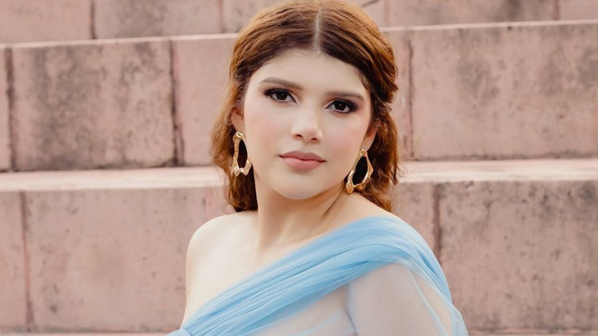 Dafne Zapata con vestido azul y maquillada