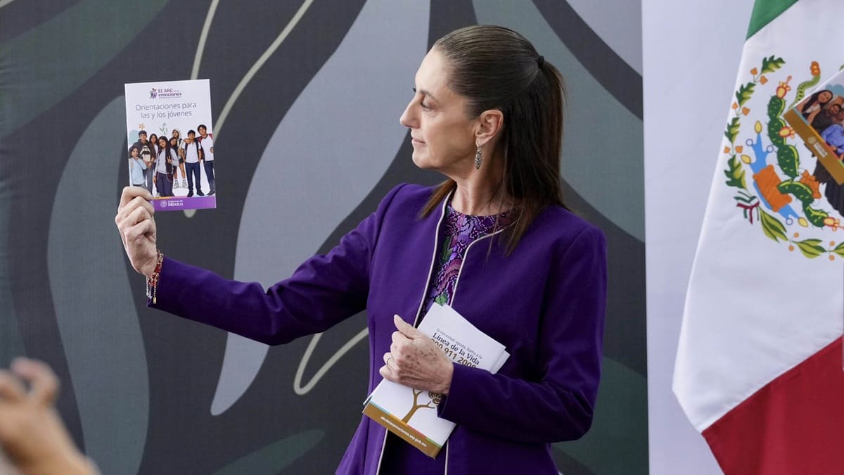 Claudia Sheinbaum muestra unas hojas a un auditorio