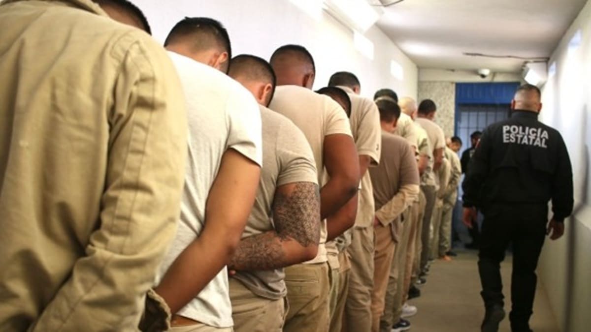 Reos formados y custodiados por un policía estatal