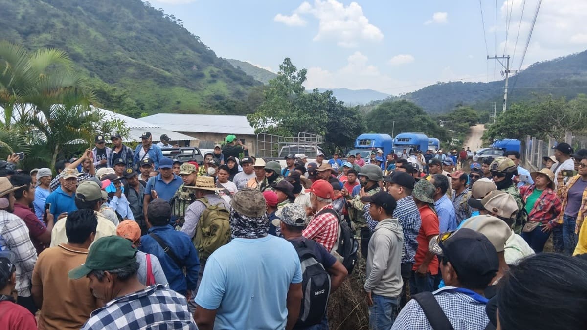 Un grupo numeroso de personas reunidas en un terreno rural