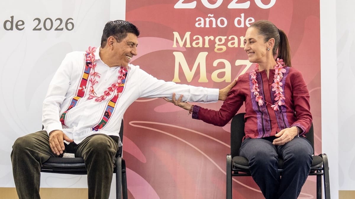 Salomón Jara y Claudia Sheinbaum sentados e intercambiando saludos sonrientes