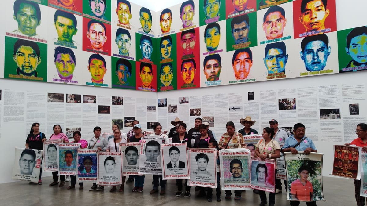Retratos de los 43 estudiantes desaparecidos de Ayotzinapa con sus padres al pie en el Museo Universitario Arte Contemporáneo en la CDMX