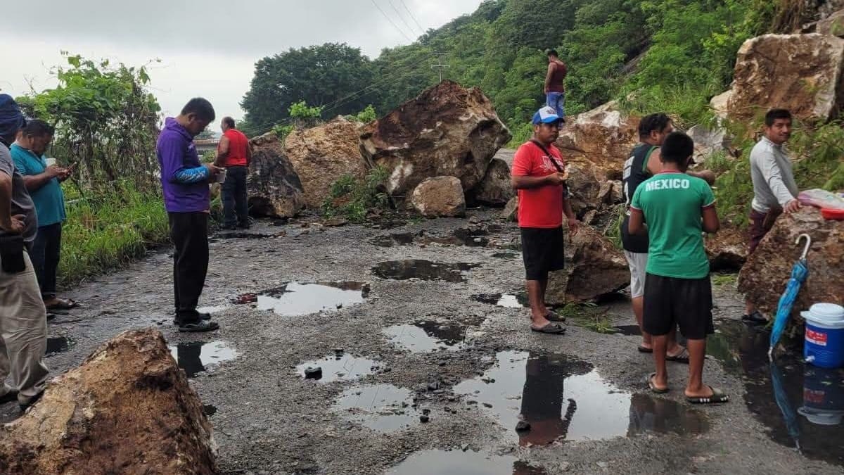 Varias personas sobre una carretera obstruida por escombros