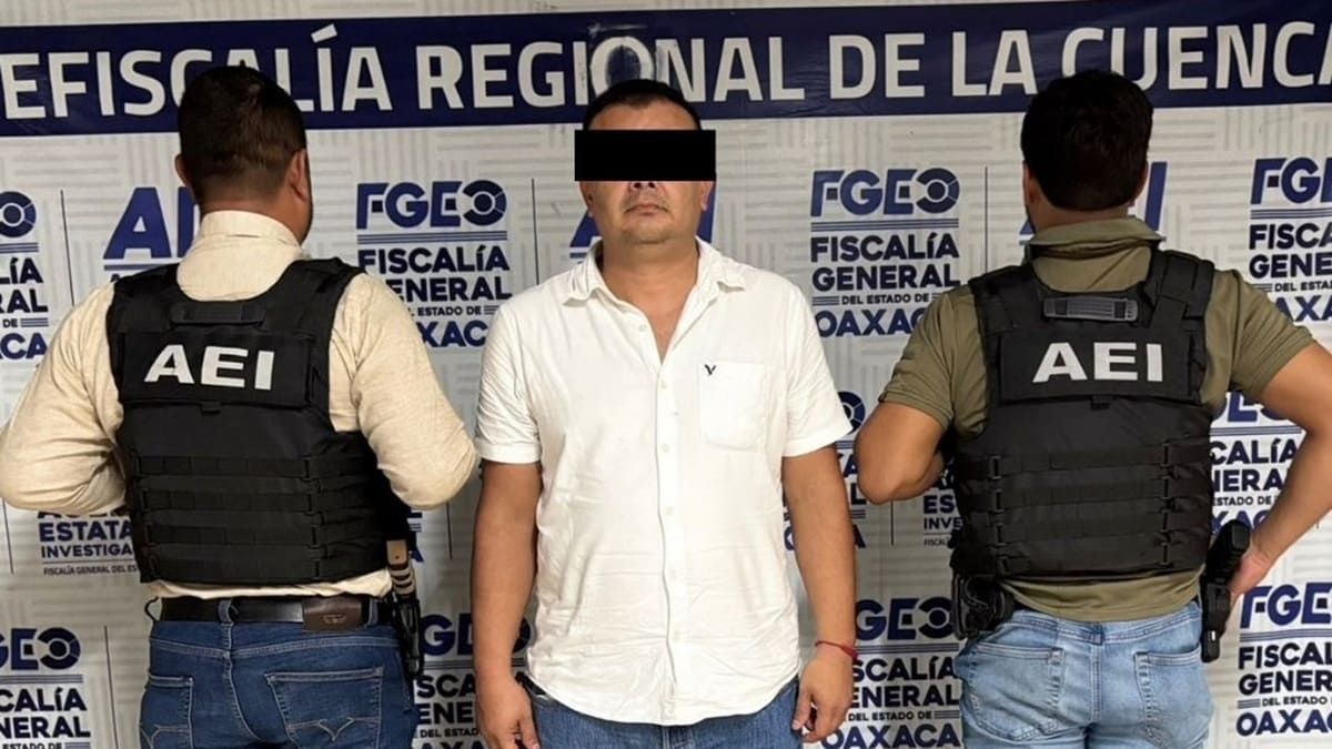 Hombre adulto con camisa blanca y los ojos protegidos por una franja negra por mandato de ley