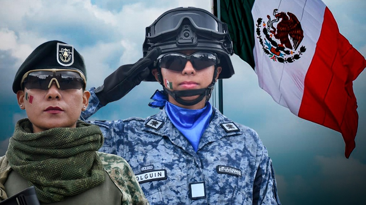 Dos mujeres del Ejército Mexicano luciendo sus uniformes y saludando junto a la Bandera de México.